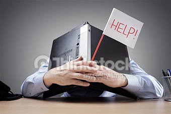 Frustrated and overworked businessman burying his head under a laptop computer asking for help